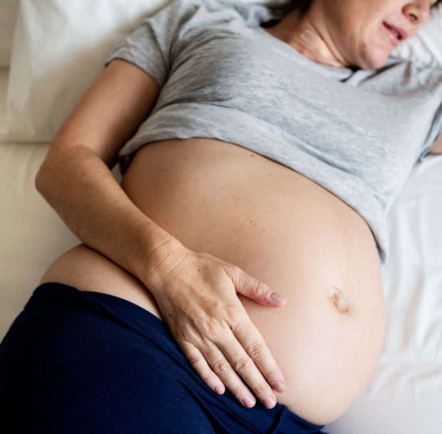 pregnant-woman-sleeping-on-the-bed-PPCSG3H