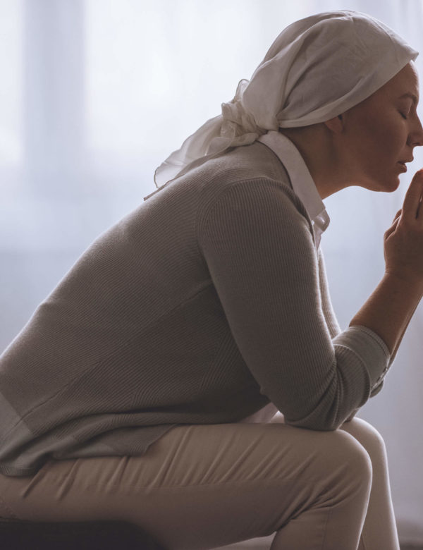 side-view-of-sick-mature-woman-in-kerchief-praying-DSYRR8J