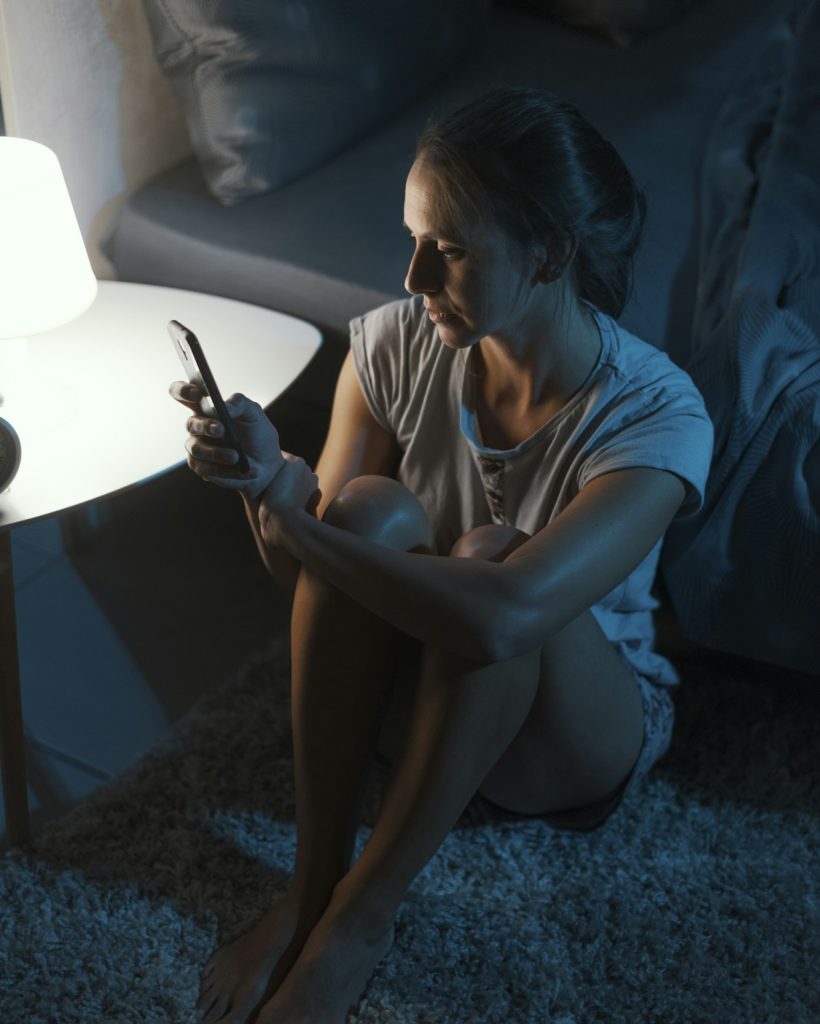 Woman suffering from insomnia and checking her phone